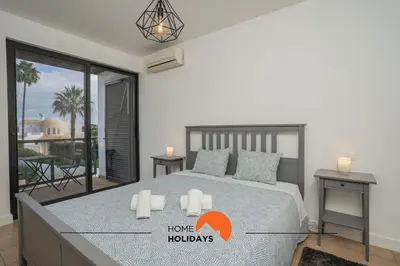 a bedroom with a large bed and a balcony at #111 Ocean View by Home Holidays in Albufeira