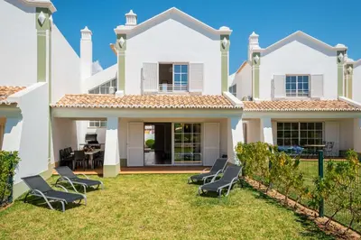 a large white house with chairs on the lawn at Beachsun Gale - beautiful villa close to beach in Galé