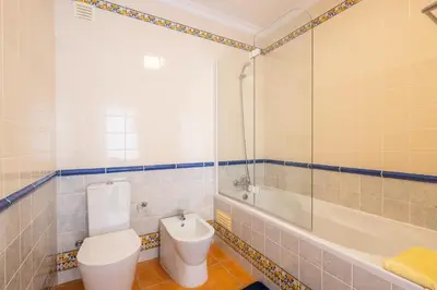 a bathroom with a toilet and a tub and a sink at Beachsun Gale - beautiful villa close to beach in Galé