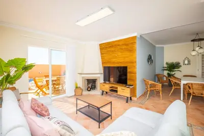 a living room with a white couch and a tv at Villa Habitate - pool fence & heating beach bars in Albufeira