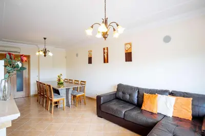 a living room with a leather couch and a table at Apartment Hugo - Complex perfect for families in Albufeira