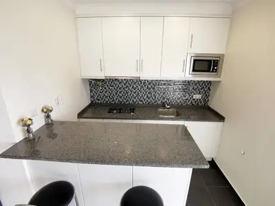 a kitchen with white cabinets and a granite counter top at Vilamoura Neptuno in Quarteira