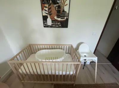 a crib with a dog bed and a stool at Muito Sol in Albufeira