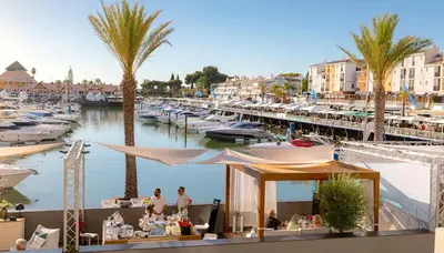 a marina with boats and people sitting at tables at AZULEJOS em VILAMOURA PORTUGAL in Vilamoura