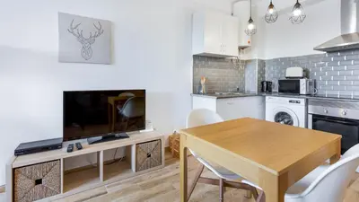 a kitchen and dining room with a table and a television at Terraços do Mar Apartment W/ Pool by LovelyStay in Vilamoura