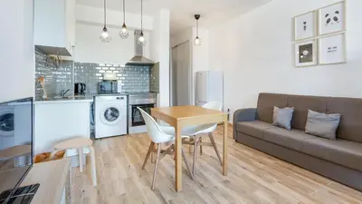 a kitchen and living room with a table and a couch at Terraços do Mar Apartment W/ Pool by LovelyStay in Vilamoura