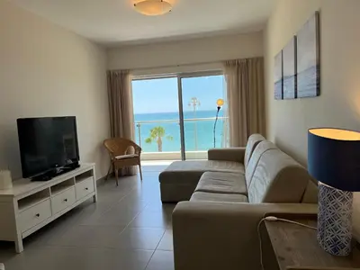 a living room with a couch and a flat screen tv at Pure Sea - Beach Apartment in Quarteira