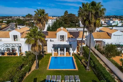 an aerial view of a house with a swimming pool and palm trees at Villa Luz do Atlantico by OCvillas in Galé