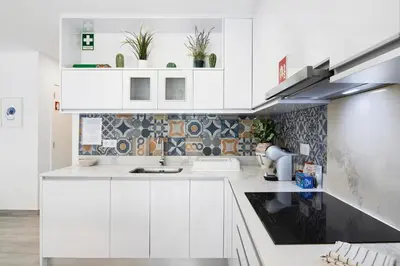 a white kitchen with white cabinets and a sink at Apartamento Acácia in Vale do Lobo