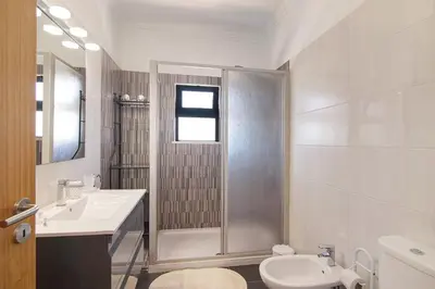a bathroom with a shower and a sink and a toilet at Villa Formosa in Almancil