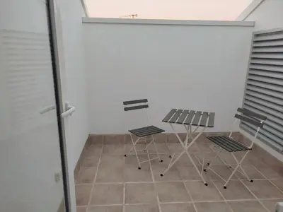 two chairs and a table in a room at Watermelon Sugar Apartment in Faro