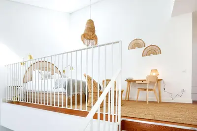 a white room with a crib and a table at Under the moon in Faro