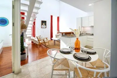 a kitchen and dining room with a white table and chairs at Under the moon in Faro