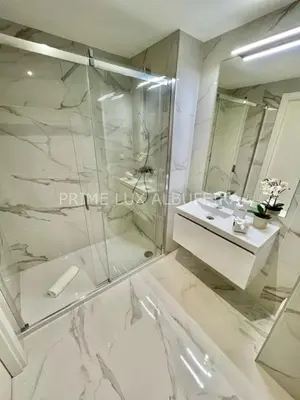 a bathroom with a glass shower and a sink at Prime Lux Albufeira in Albufeira