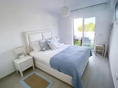 a white bedroom with a large bed and a window at Beautiful apartment set in the heart of Quinta - Newly Refurbished in Almancil