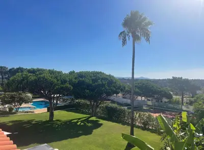 a palm tree in a yard with a swimming pool at Beautiful apartment set in the heart of Quinta - Newly Refurbished in Almancil
