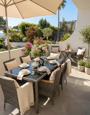 a dining table with chairs and an umbrella on a patio at Beautiful apartment set in the heart of Quinta - Newly Refurbished in Almancil