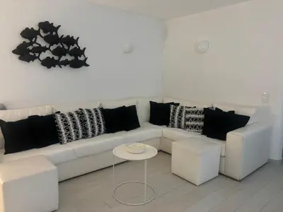 a white couch with black pillows and a table at Beautiful apartment set in the heart of Quinta - Newly Refurbished in Almancil