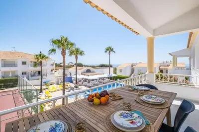 a table on a balcony with a view of the ocean at Apartment Maria - Complex with tennis court and restaurant,pool in Albufeira