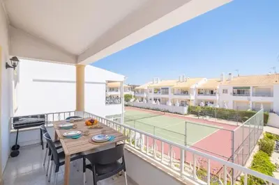 a balcony with a table and a tennis court at Apartment Maria - Complex with tennis court and restaurant,pool in Albufeira