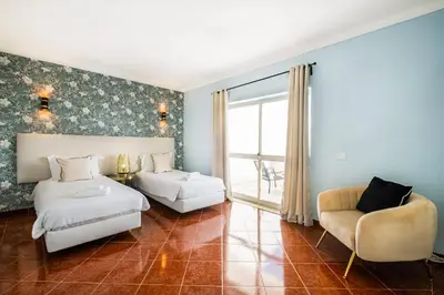 a bedroom with a bed and a couch and a chair at Villa Loria - beautiful panoramic views in Albufeira