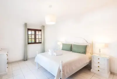 a white bedroom with a bed and a window at Patroves Ranch - private pool & sea views in Albufeira