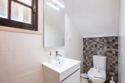 a white bathroom with a sink and a toilet at Patroves Ranch - private pool & sea views in Albufeira