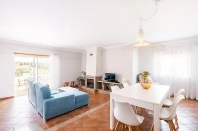 a living room with a table and a blue couch at Apartment Esta - Tennis court and pool in Albufeira