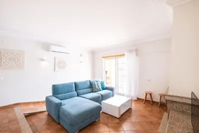a living room with a blue couch and a table at Apartment Esta - Tennis court and pool in Albufeira