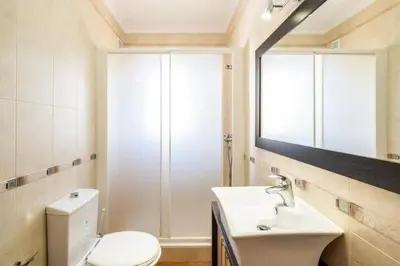 a bathroom with a toilet and a sink and a mirror at Apartment Esta - Tennis court and pool in Albufeira
