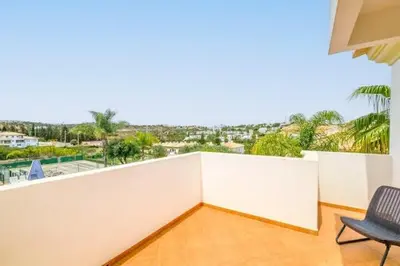 a balcony with a chair and a white wall at Apartment Esta - Tennis court and pool in Albufeira