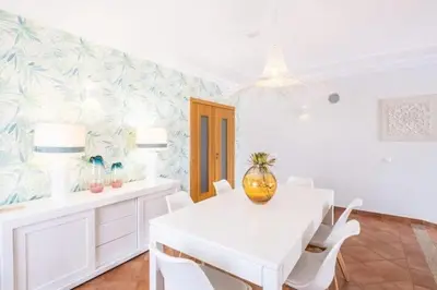 a white dining room with a white table and chairs at Apartment Esta - Tennis court and pool in Albufeira