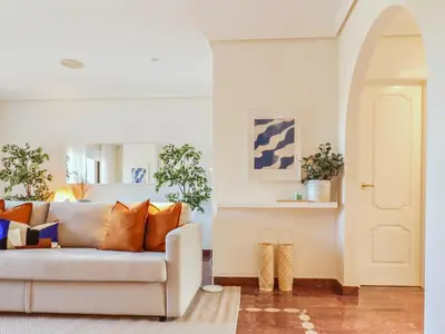 a living room with a white couch with orange pillows at Falésia's Harmony -5min to the beach by LovelyStay in Albufeira
