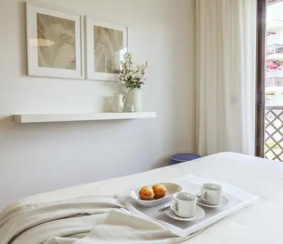a tray with two cups and oranges on a bed at Falésia's Harmony -5min to the beach by LovelyStay in Albufeira