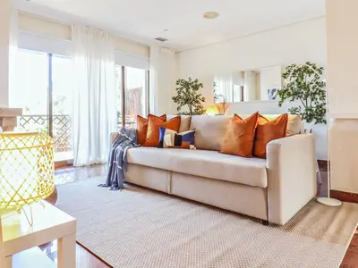 a living room with a couch with orange pillows at Falésia's Harmony -5min to the beach by LovelyStay in Albufeira