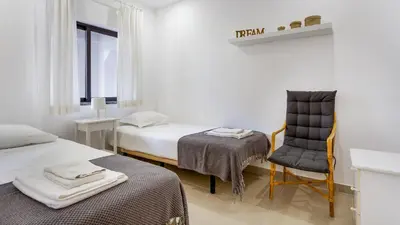 a room with two beds and a chair and a desk at Sweet As by LovelyStay in Quarteira