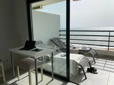 a room with a table and a laptop on a table at Seaview & Sunsets Apartment in Quarteira