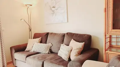 a brown couch in a living room with pillows on it at Beach Lover's Paradise: 3BR 2 min from the Sand in Quarteira