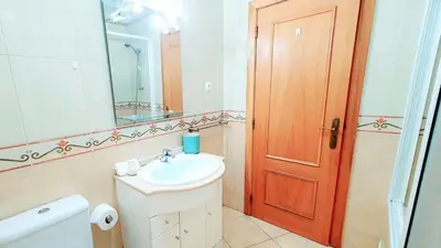 a bathroom with a sink and a toilet and a mirror at Beach Lover's Paradise: 3BR 2 min from the Sand in Quarteira