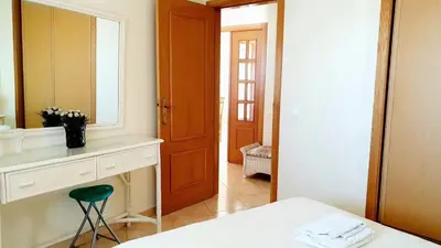 a bathroom with a sink and a mirror and a stool at Beach Lover's Paradise: 3BR 2 min from the Sand in Quarteira