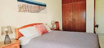 a bedroom with a bed and a wooden door at Seaside Serenity: 1BR with Breathtaking Ocean View in Quarteira