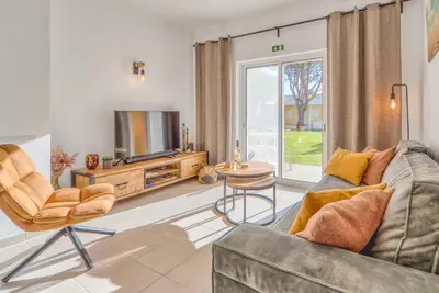 a living room with a couch and a tv at Casa Serena, Portugal in Guia