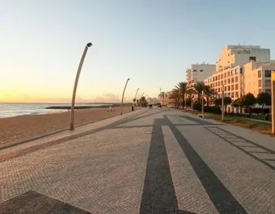 an empty street next to the beach with buildings at Quarteira Beach Vacation: 2BR steps to the sand in Quarteira