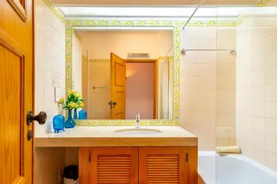 a bathroom with a sink and a mirror and a tub at Family Apartment Pool & Terrace in Vilamoura