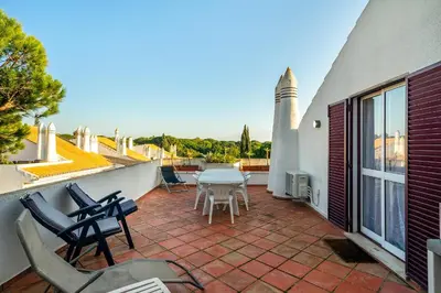 a patio with chairs and a table on a balcony at Family Apartment Pool & Terrace in Vilamoura