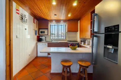 a kitchen with a refrigerator and two stools in it at Family Apartment Pool & Terrace in Vilamoura