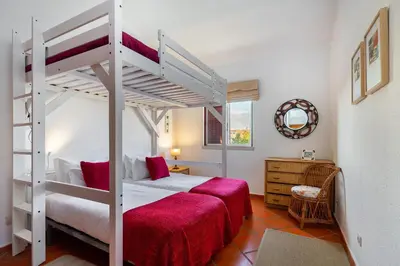 a bedroom with a bunk bed with a red blanket at Family Apartment Pool & Terrace in Vilamoura