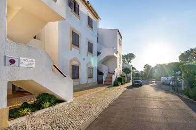 a street with a building and a car parked on the road at Family Apartment Pool & Terrace in Vilamoura