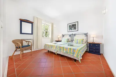 a bedroom with a bed and a chair at Villa Farol by OCvillas in Galé