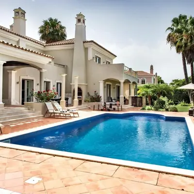 a swimming pool in front of a house at Villa Millennium luxury villa relaxing location in Almancil